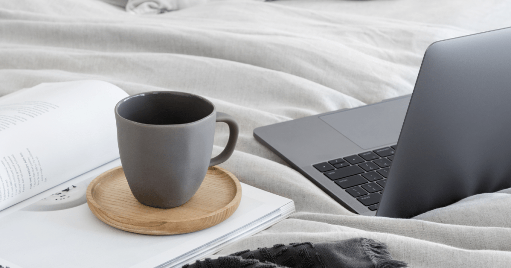 coffee cup, blanket and laptop on a bed, calming yourself down